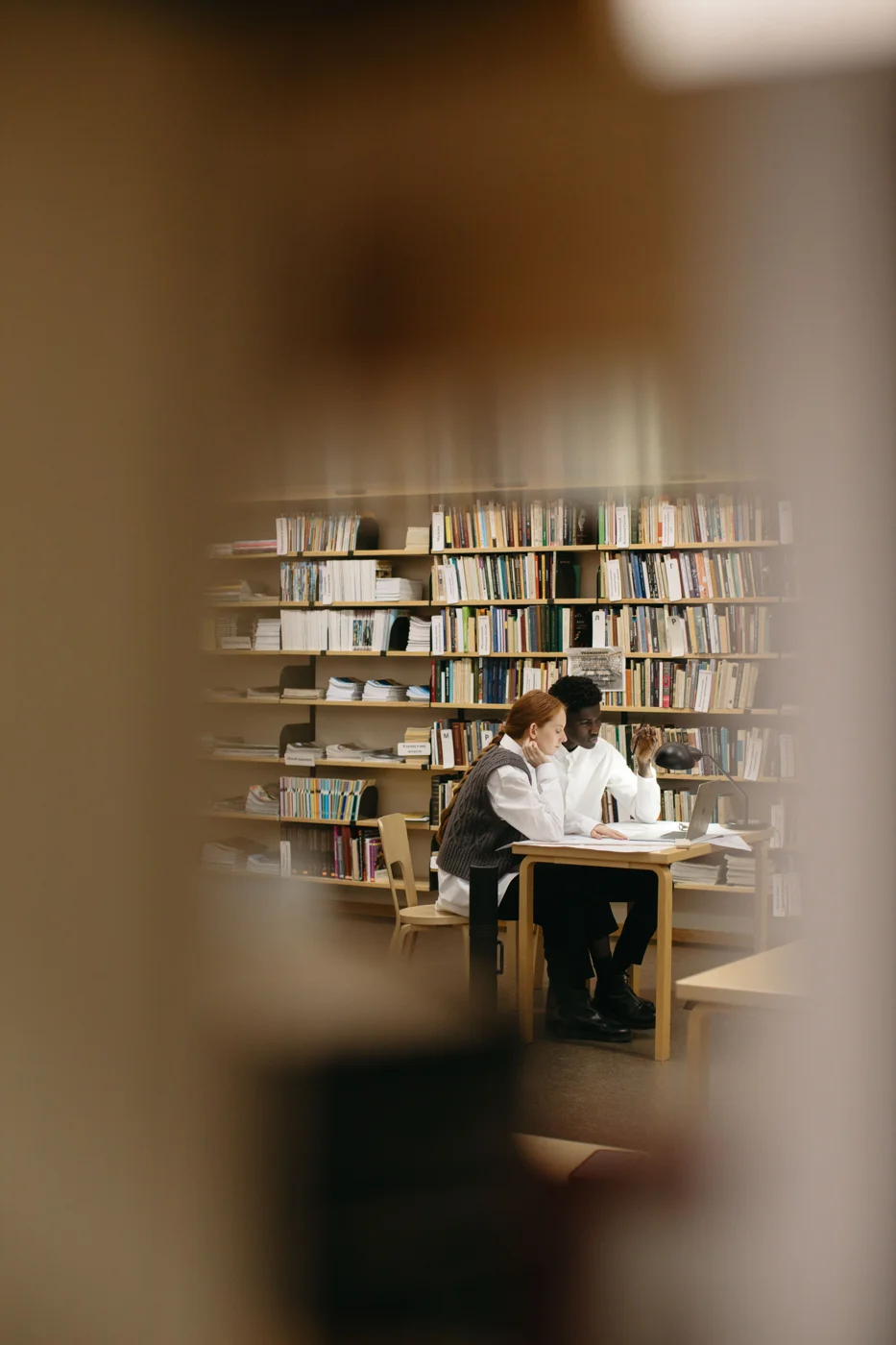 Estudantes compartilhando uma mesa na biblioteca