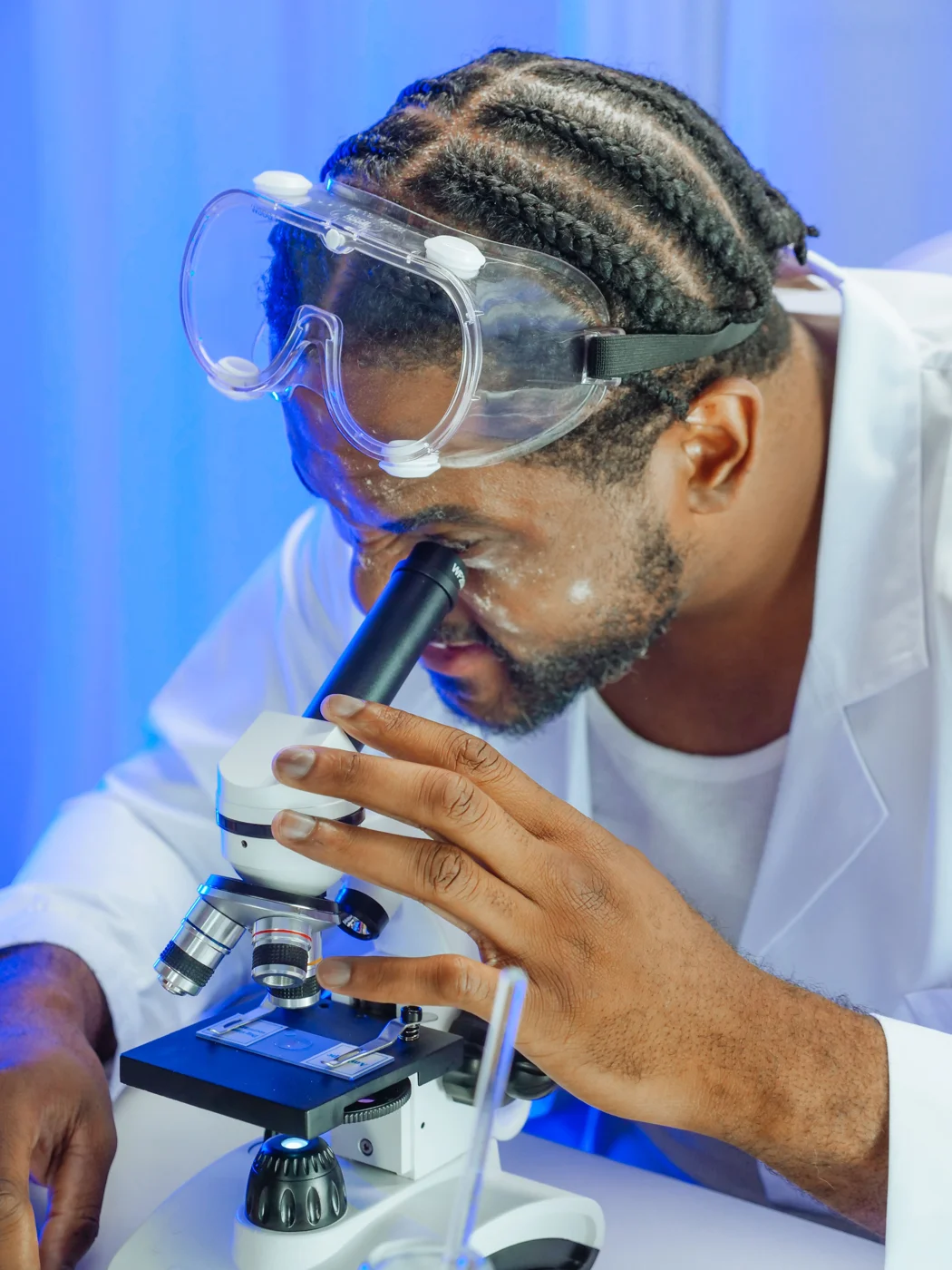 Pesquisador observando um microscópio em laboratório
